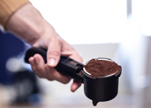 Equipaggi preparare un caffè in una macchinetta del caffè a casa