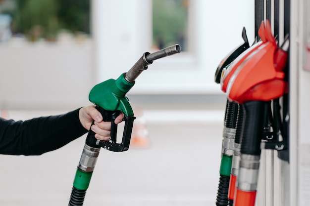 Equipaggia la mano utilizzando l'ugello del carburante alla stazione di servizio