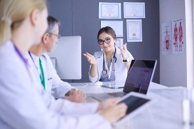 Equipe medica seria che utilizza un laptop in un ufficio luminoso