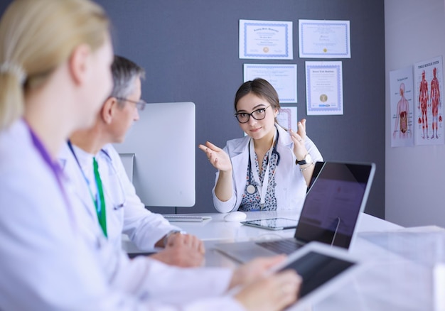 Equipe medica seria che utilizza un laptop in un ufficio luminoso