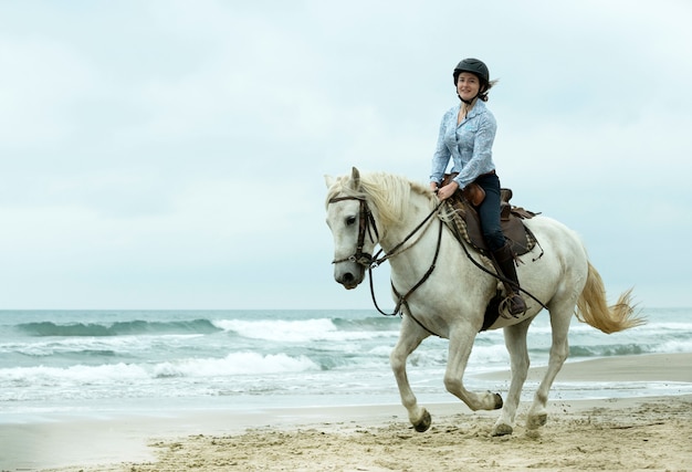 Equitazione ragazza e cavallo in spiaggia