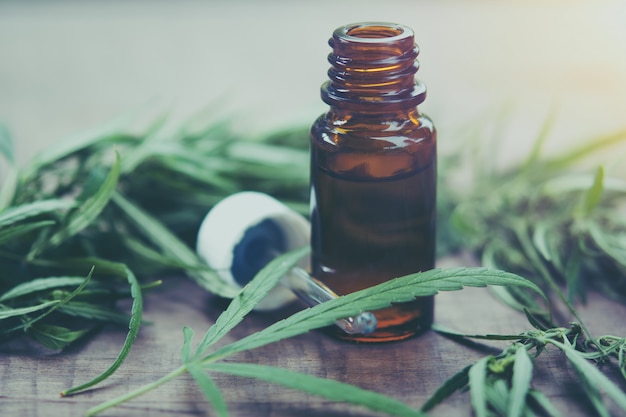 Erba di cannabis e foglie con estratti di olio in barattoli.