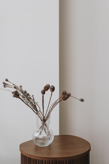 Erba di pampa secca e bouquet di fiori in vaso di vetro sul tavolino in legno contro il muro bianco Estetica minimalista casa soggiorno interior design decorazione dettagli Elegante arredamento appartamento di lusso