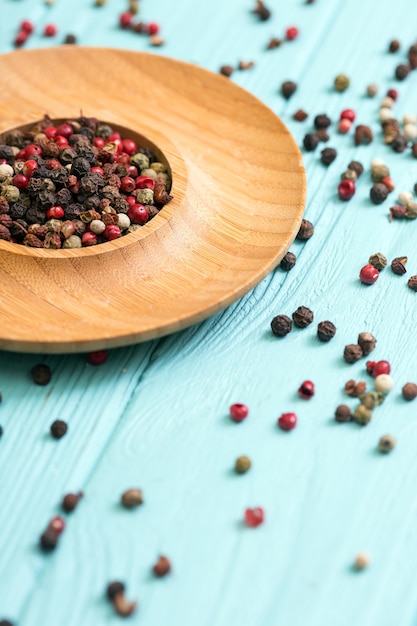 Erbe e spezie. mix di peperoni in piatti di legno su fondo blu