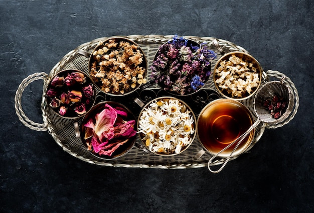 Erbe medicinali essiccate in tazze e tisane. Concetto di erboristeria, vista dall'alto