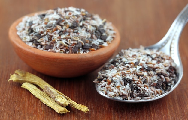Erbe medicinali isabgul, semi di basilico e yastimadhu su una superficie in legno