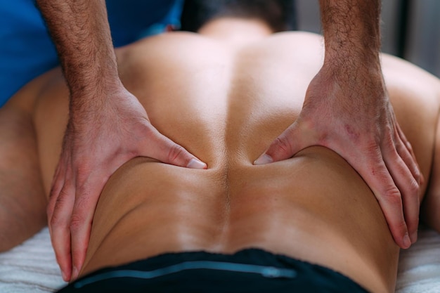Ernia del disco Massaggio manuale Trattamento Fisioterapista che massaggia la parte bassa della schiena