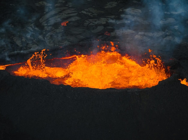 Eruzione di un vulcano in Islanda cratere di vetta espulsione di gas e lava fusa che si riversa da una ventola