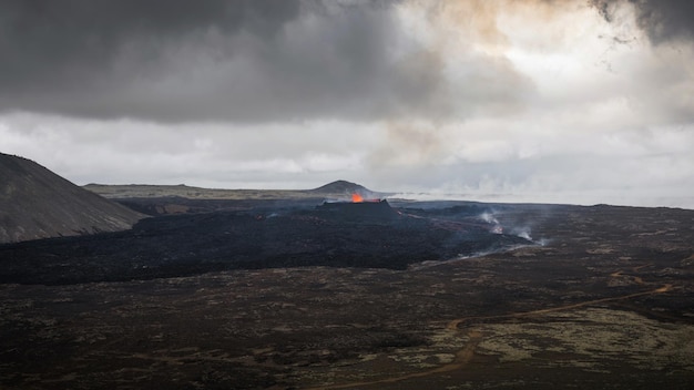 Eruzione di un vulcano in Islanda una fontana di lava rossa brillante che si eleva sopra un'apertura e un flusso di lava