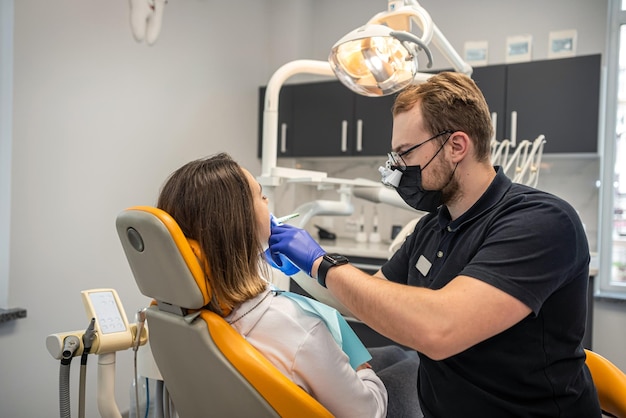 Esame di un dentista che cura un paziente in uno studio dentistico