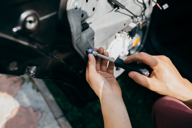 Esame e riparazione di un'auto all'aperto.