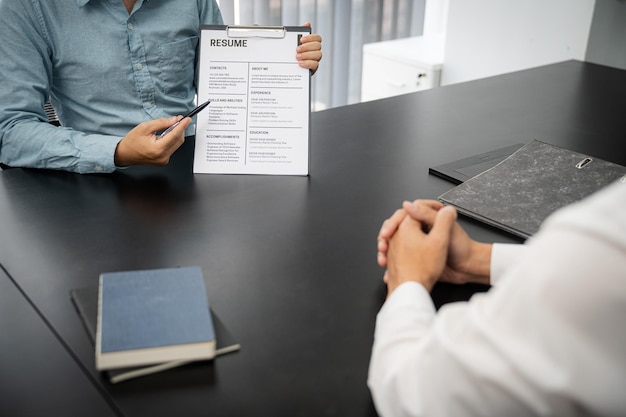 Esaminatore che legge un curriculum durante il colloquio di lavoro in ufficio Concetto di affari e risorse umane