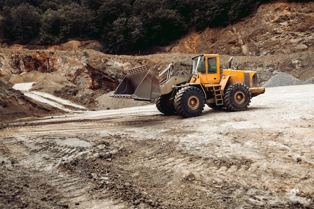 Escavatore a cucchiaia rovescia industriale e pala gommata che lavorano in cantiere autostradale