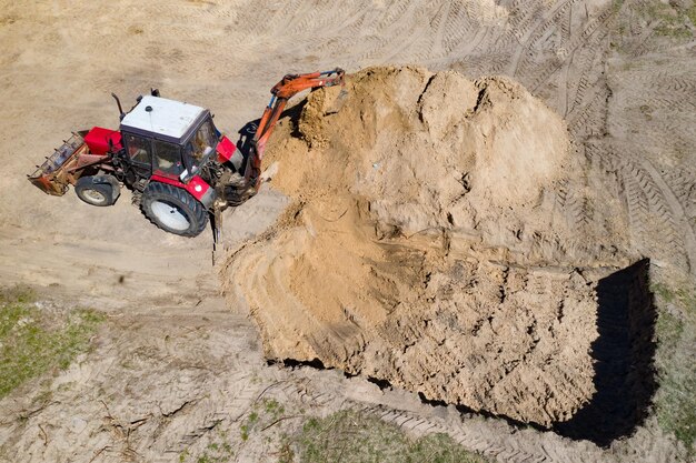 Escavatore al lavoro di scavo in un cantiere edile vista Arial