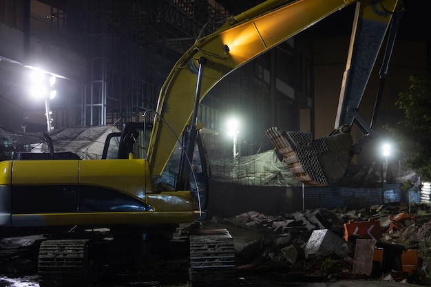 Escavatore giallo che lavora di notte per strada