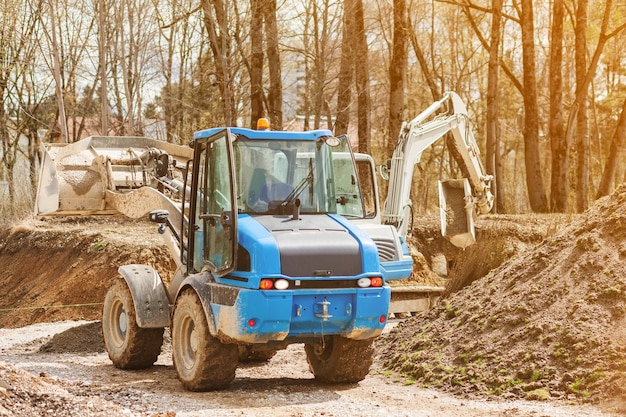 Escavatore posa Strada in parco pubblico Lavori stradali in luogo urbano Posa di comunicazioni sotto strada