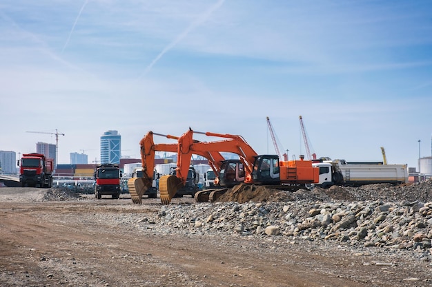 Escavatori o escavatori con autocarri con cassone ribaltabile in cantiere o movimento terra in lavori di protezione della costa a Batumi