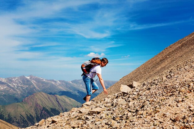 Escursione dell'uomo in cima alla montagna, successo, vincitore, un uomo con uno zaino sta in cima alla montagna. montagne di Karachay-Cherkessia.