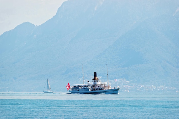Escursione in traghetto con bandiera svizzera sul lago di Ginevra presso l'argine di Ouchy a Losanna, Svizzera. Persone a bordo