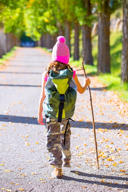 Escursionismo bambina con bastone da passeggio e zaino vista posteriore