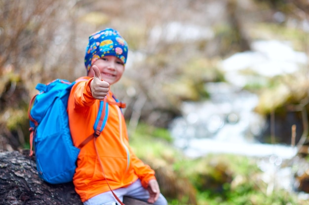 Escursionismo bambino bambina viaggio con zaini pollice in su Sport all'aria aperta ritratto primo piano