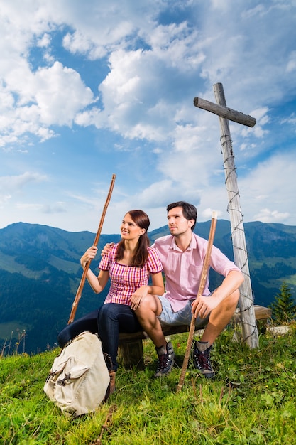 Escursionismo - Giovane coppia seduta sulla cima della montagna all'incrocio delle Alpi bavaresi e gode del panorama nel tempo libero o in vacanza