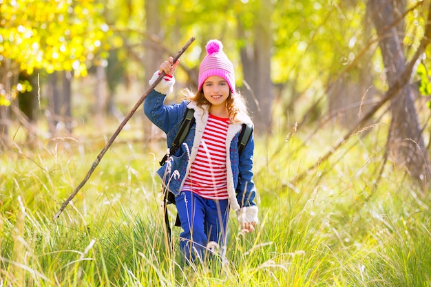 Escursionismo ragazza bambino con zaino nella foresta di pioppo autum