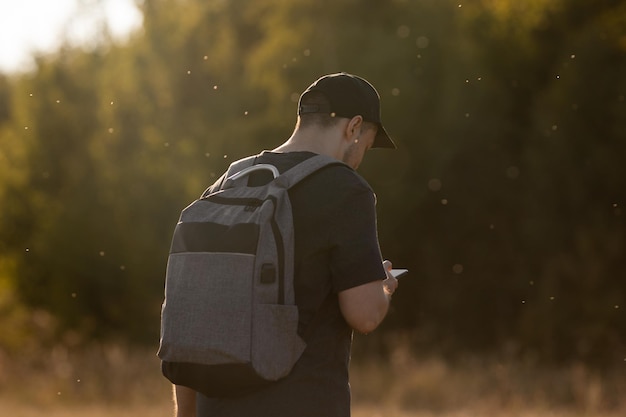 Escursionista con zaino che fa un percorso attraverso la campagna Uomo che usa il suo smartphone come gps e consulta la mappa A