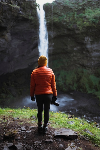 Escursionista femmina con vista sulla cascata Kvernufoss nel sud dell'Islanda