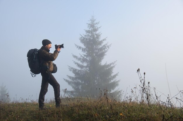 Escursionista fotografo che cattura foto della natura con la fotocamera digitale