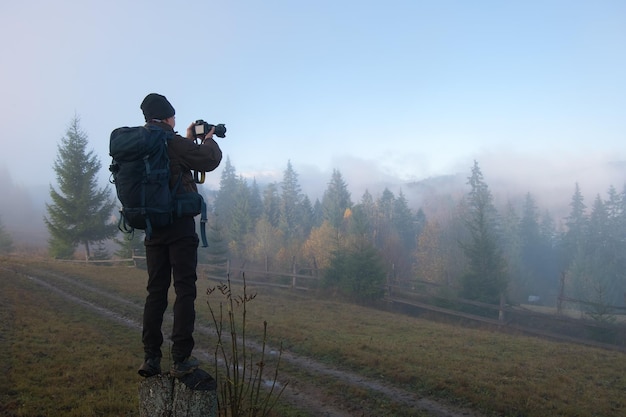 Escursionista fotografo che cattura foto della natura con la fotocamera digitale