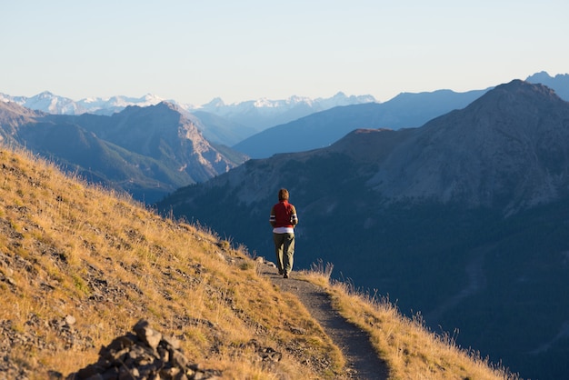 Escursionista in alta montagna paesaggio roccioso. Avventure estive sulle Alpi francesi italiane,