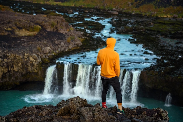 Escursionista in piedi sul bordo della cascata thjofafoss in Islanda