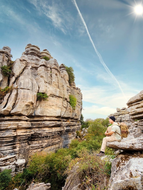 Escursionista seduto su una roccia guardando un paesaggio roccioso Uomo all'aria aperta Torcal de Antequera Spagna