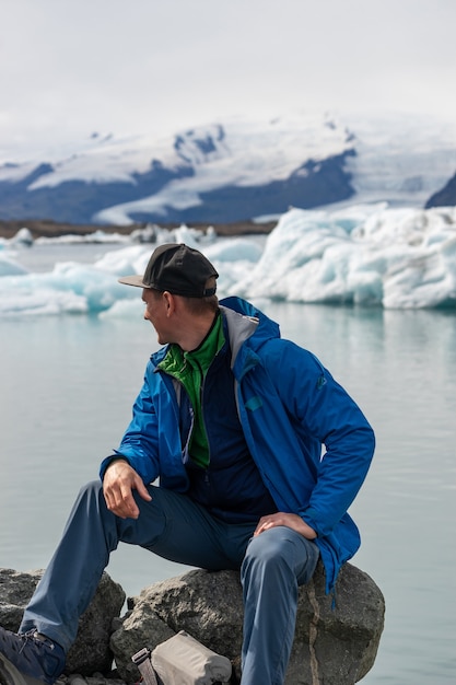 Escursionista turista guardando vista Iceberg paesaggio con iceberg giganti e lago. La natura artica pesantemente colpita dai cambiamenti climatici