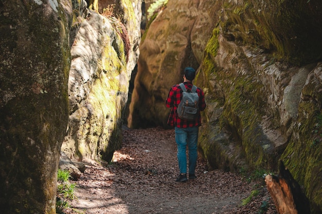 Escursionista uomo con zaino a piedi dal sentiero nel canyon