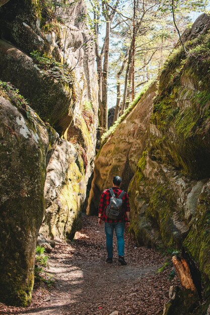 Escursionista uomo con zaino a piedi dal sentiero nel canyon