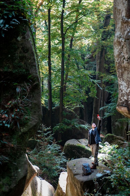 Escursionista uomo con zaino in canyon con foresta