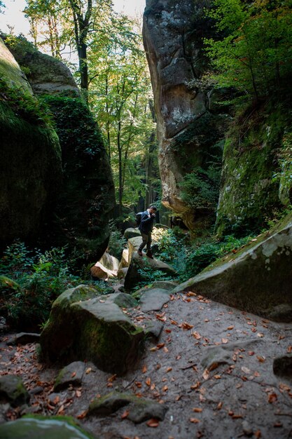 Escursionista uomo con zaino in canyon con foresta