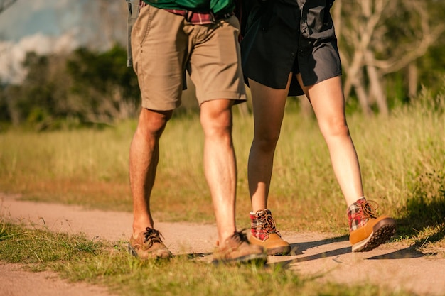 Escursionisti con zaini che camminano attraverso il sentiero nel bosco indossando scarponi da montagna con particolare attenzione alle scarpe.