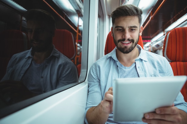 Esecutivo utilizzando la tavoletta digitale che viaggiano in treno