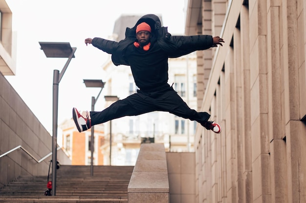 Esecutore dell'artista di breakdance hip-hop alla moda che salta con il concetto di stile di vita urbano a braccia aperte