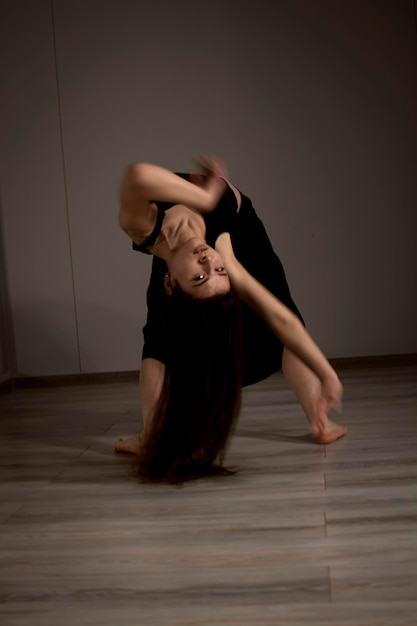 Esecutore di danza snello e flessibile durante una pratica di danza in uno studio moderno