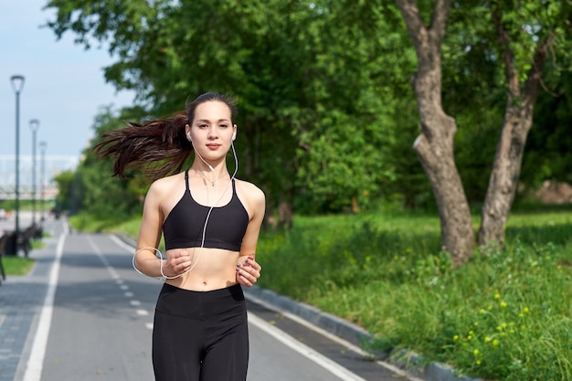 Esecuzione di donna asiatica sulla pista da corsa. Fare jogging mattutino. L'allenamento dell'atleta