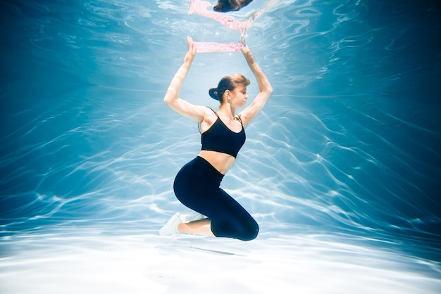 Esecuzione di donna che fa jogging. Ragazza sott'acqua, freschezza e leggerezza, fitness e nuoto. Sport e stile di vita