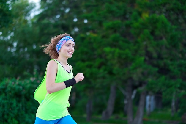 Esecuzione di donna Corridore femminile Jogging durante l'allenamento all'aperto in un parco Modello di fitness ragazza in forma bella all'aperto Perdita di peso