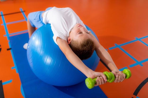 Esercizi per muscoli pettorali o pettorali per bambini con una palla fitness