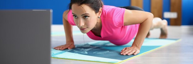 Esercizio concentrato della donna per il treno attivo di tutto il corpo in studio