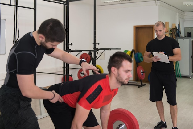 Esercizio di sollevamento pesi di gruppo in palestra per uomini e ragazze