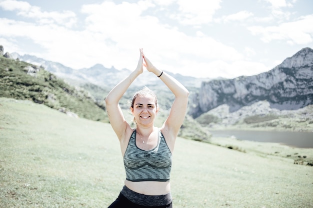 Esercizio e posa della donna di stile di vita per una vita sana. La ragazza o le persone posano lo zen vitale del corpo dell'equilibrio e la meditazione per lo sfondo della montagna della natura di allenamento. Copia spazio per banner.